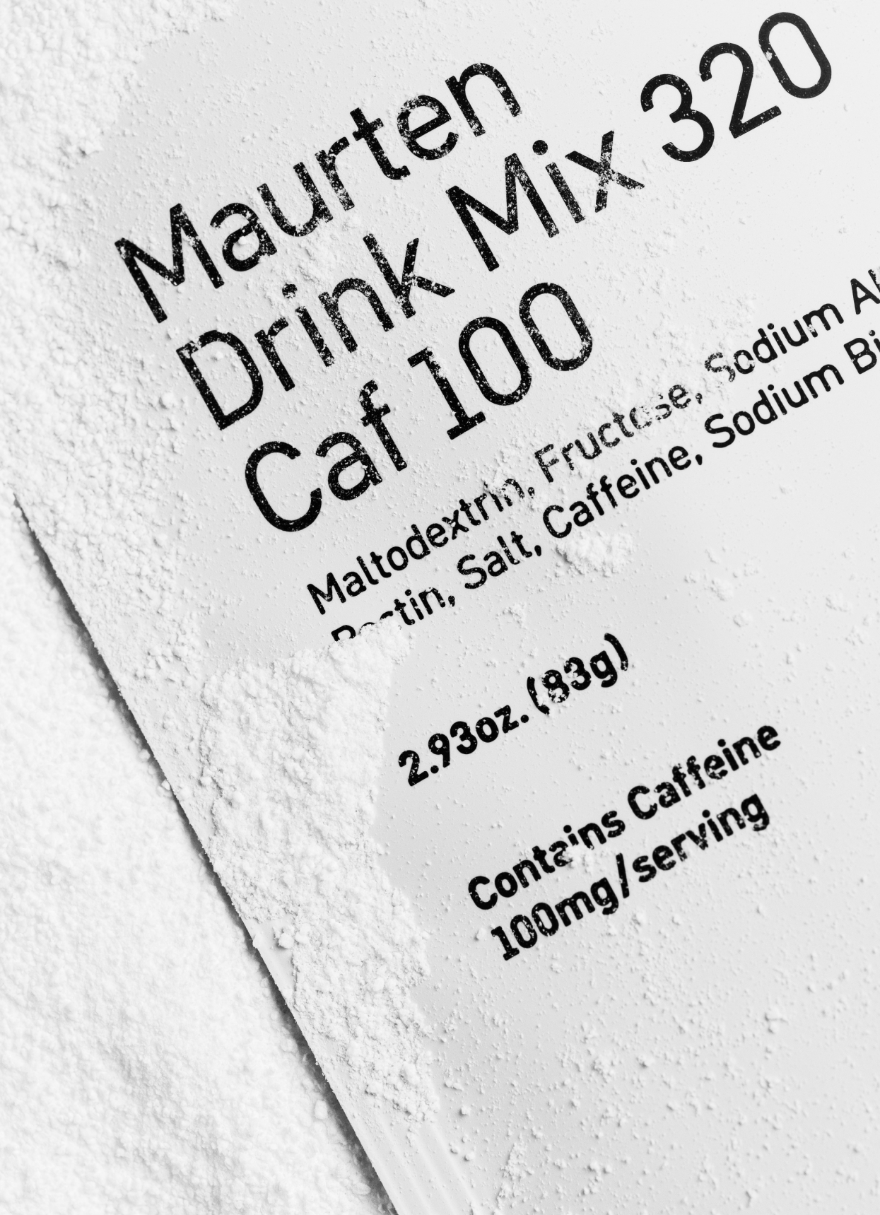 Close-up of a single packet of Maurten Fuel Drink Mix 320 CAF with 100 mg Caffeine, with powder on it.
