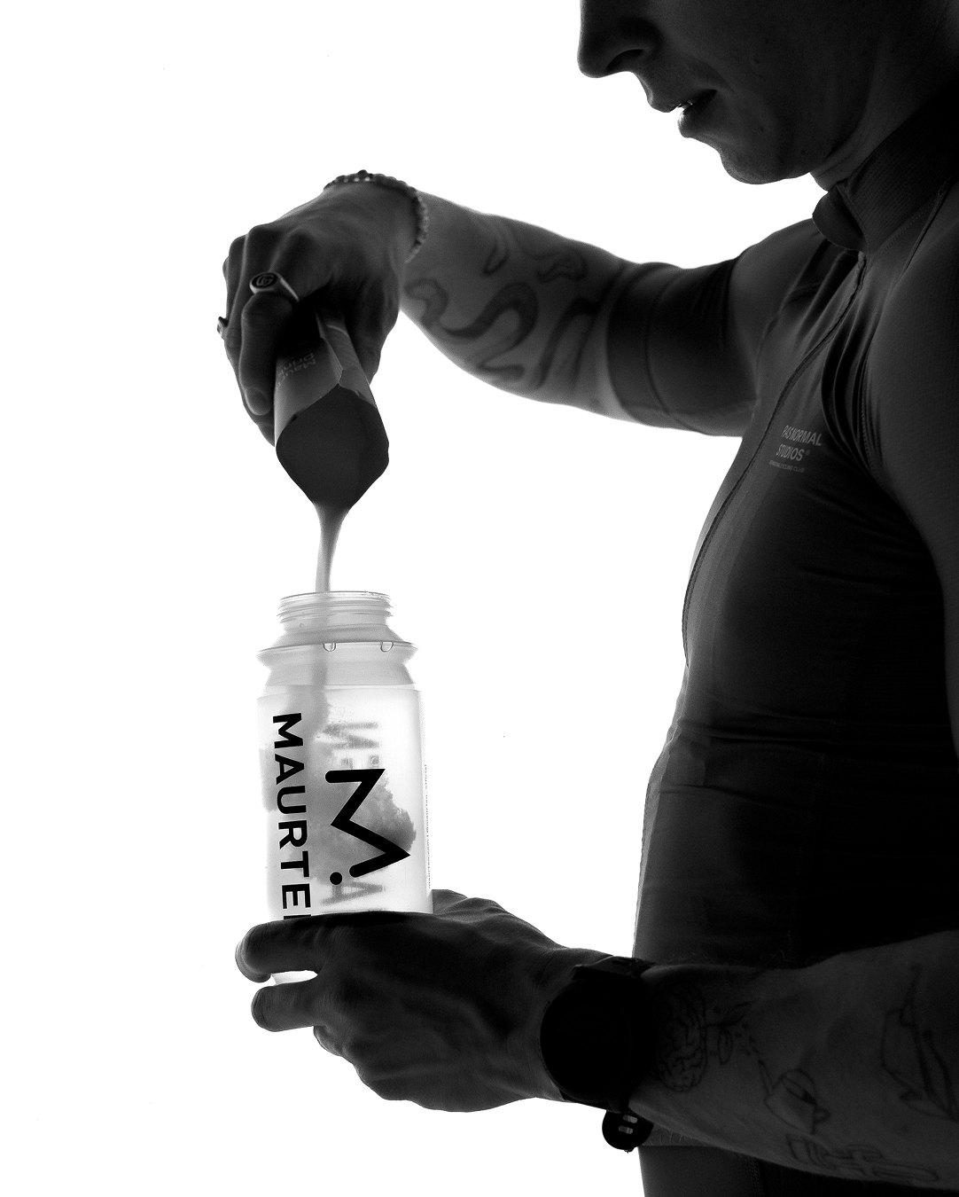 Athlete pouring Maurten Drink Mix powder into a clear Maurten bottle