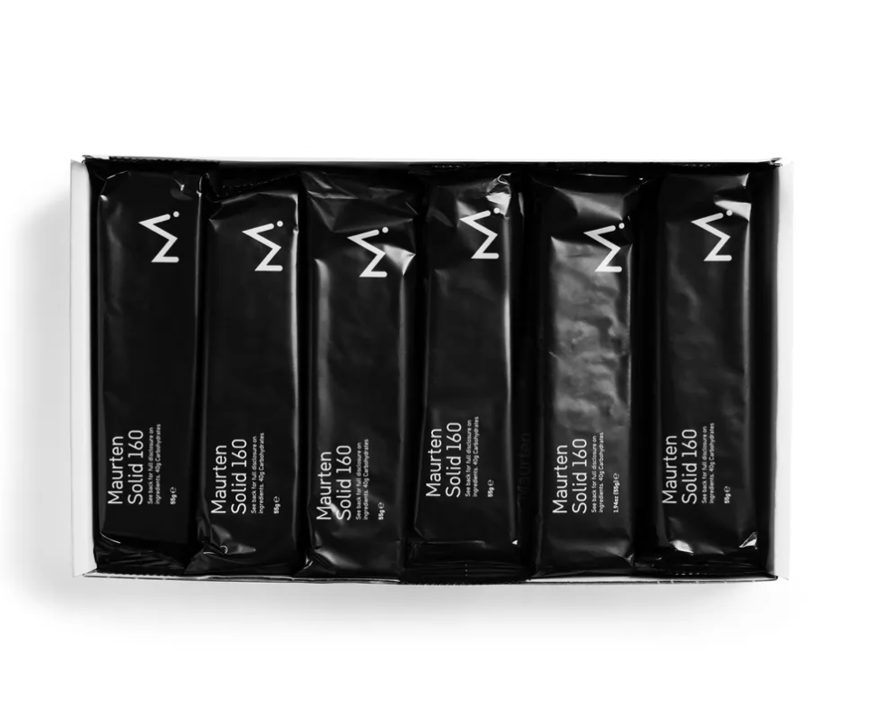 A box of 12 black Maurten Solid 160 Bar packages aligned in two rows.