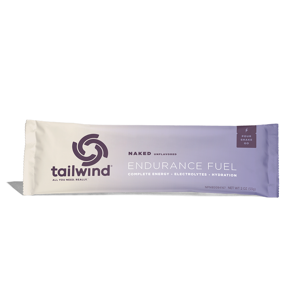 A packet of Tailwind Endurance Fuel labeled 'Naked' with a purple and white design, indicating it is a caffeine-free sports nutrition drink mix.