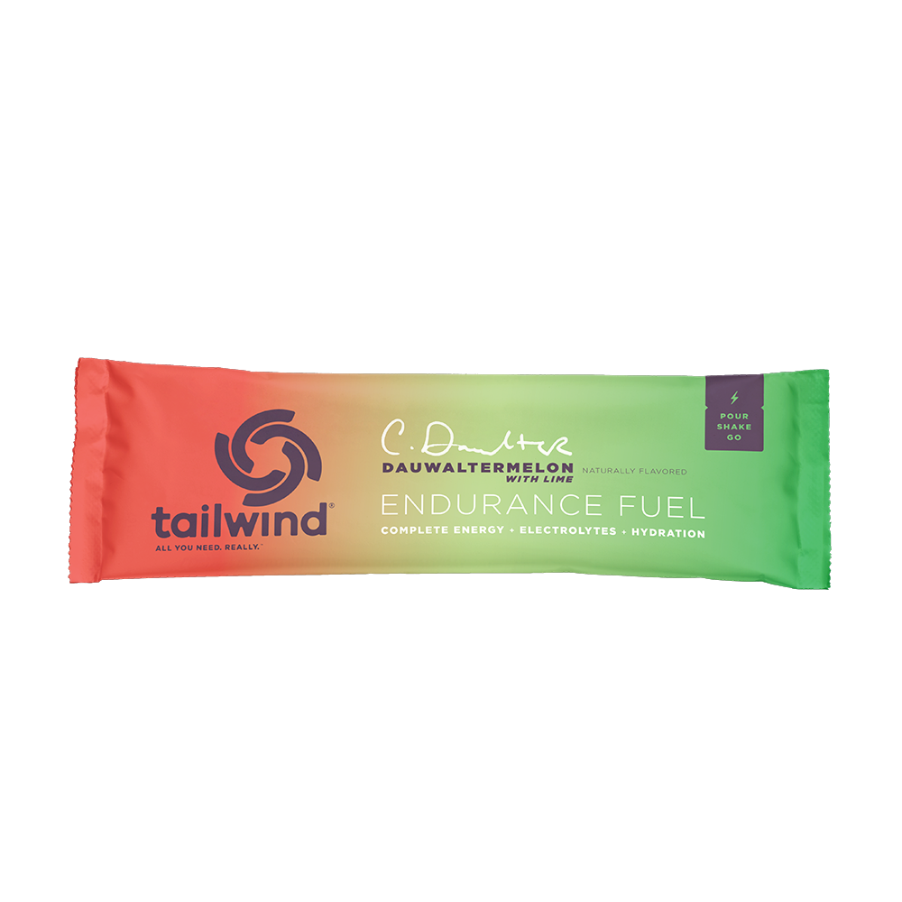 A packet of Tailwind Endurance Fuel labeled 'Dauwaltermelon' with a orange and green design, indicating it is a caffeine-free sports nutrition drink mix.