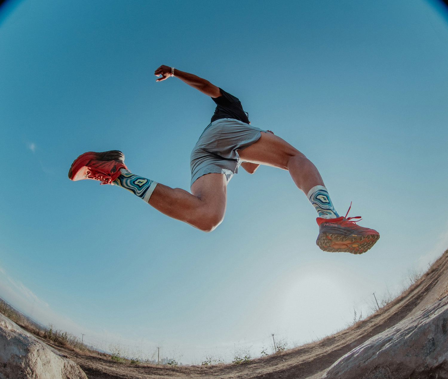 Person jumping outdoors with a clear blue sky background