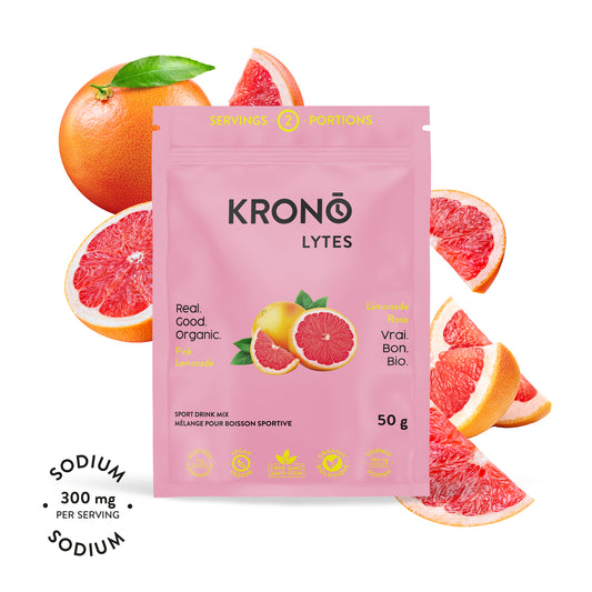 A packet of Krono Nutrition Krono Lytes with pink lemons around it. The packet indicates the product is organic, vegan, and provides a sodium content of 300 mg per serving.