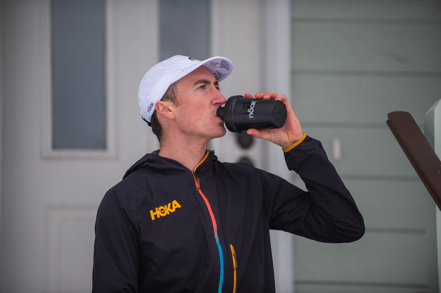 Hoka athlete drinking out of Näak Shaker Bottle