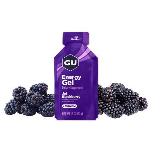 A packet of GU Energy Gel with the flavor Jet Blackberry highlighted, containing 40 mg Caffeine, with images of blackberries in the background.