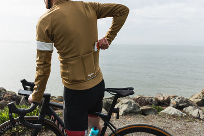Picture of a cyclist by the ocean putting Gu Chews into his cycling shirt