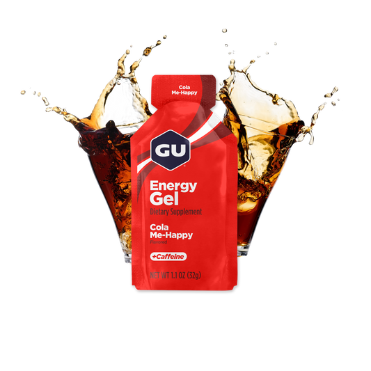A packet of GU Energy Gel with the flavour Cola Me-Happy highlighted, containing 40 mg Caffeine, with images of cola in the background.
