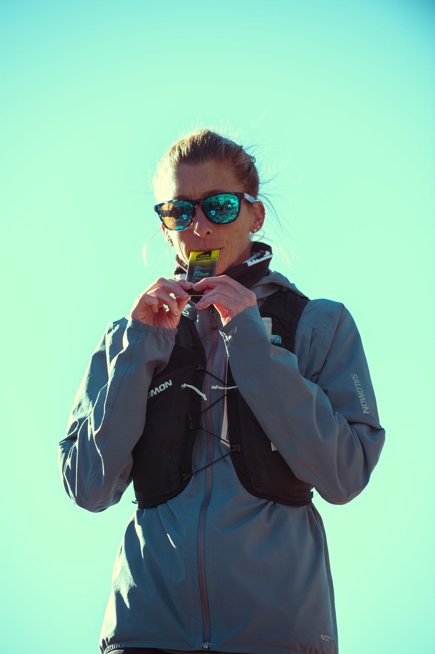 Courtney Dauwalter eating a Näak Boost  Ice Mint gel packet available at Fuel Kit