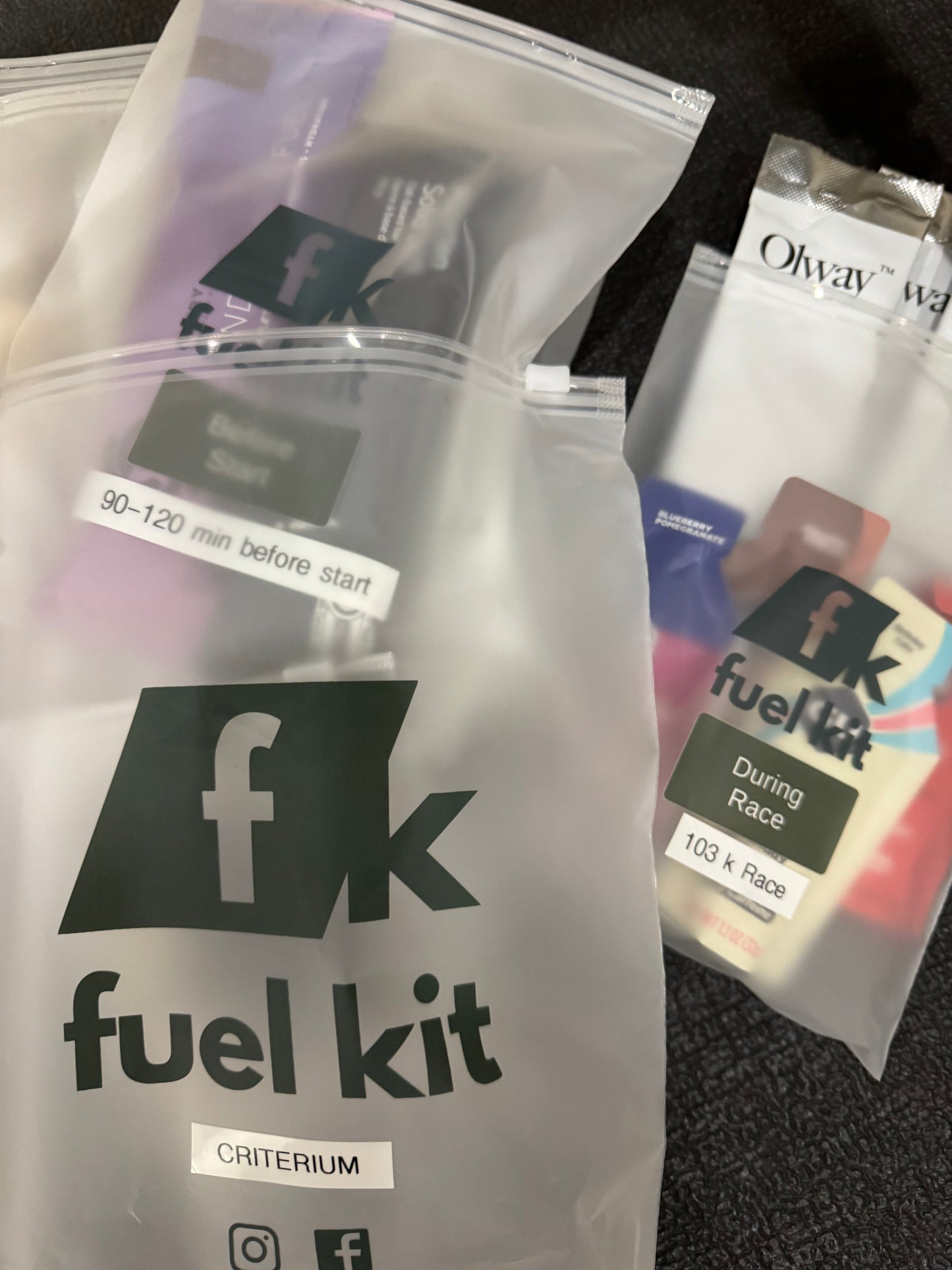 A close-up of a fuel kit organized in clear plastic zip bags on a dark textured surface available via Fuel Kit Builder.