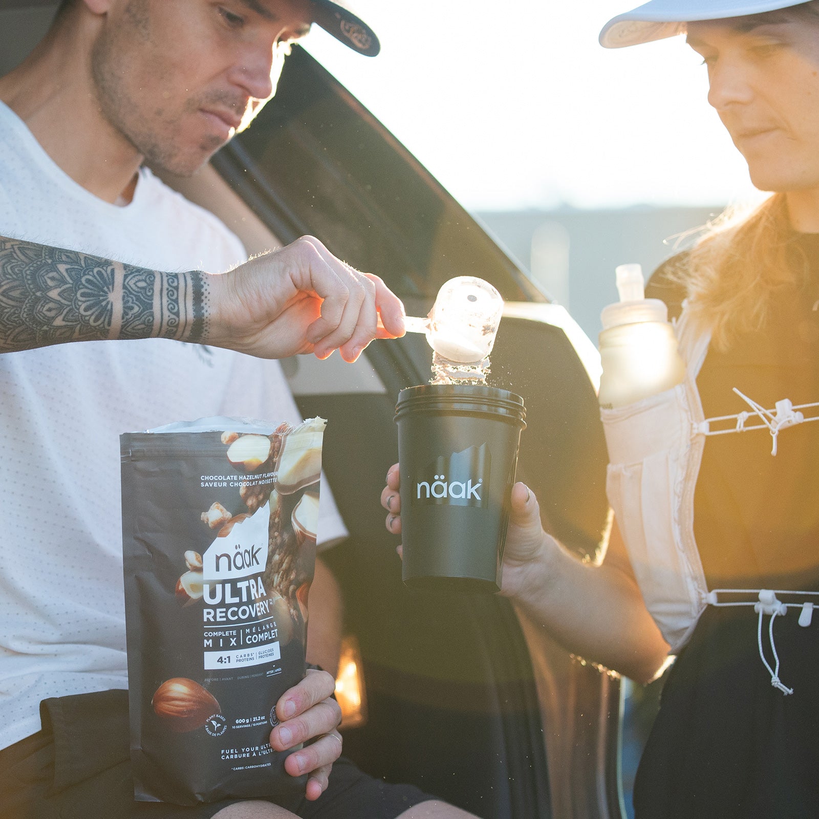Trail runners mixing protein powder in a Näak Shaker Bottle- bottle available at Fuel Kit