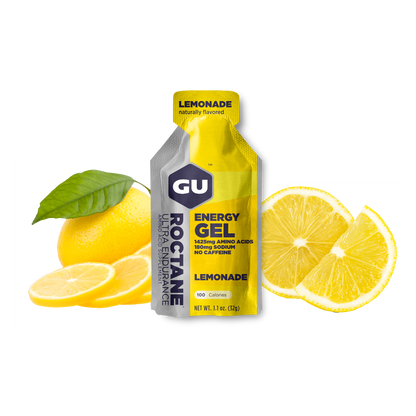 A packet of GU Roctane Energy Gel with lemonade flavor, accompanied by sliced lemons and a whole lemon on a white background.
