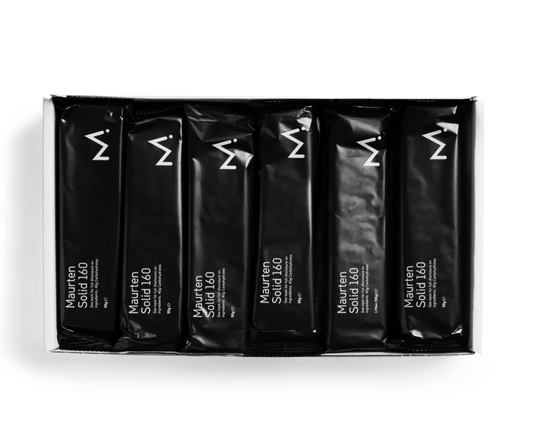 A box of 12 black Maurten Solid 160 Bar packages aligned in two rows.