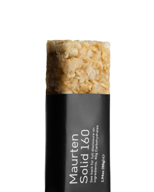 A single Maurten Solid 160 nutrition bar with visible oat and rice textures, primarily beige in color with a black wrapper.