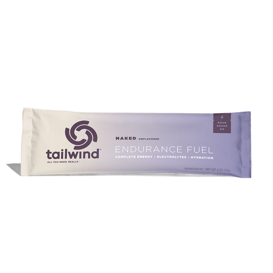 A packet of Tailwind Endurance Fuel labeled 'Naked' with a purple and white design, indicating it is a caffeine-free sports nutrition drink mix.