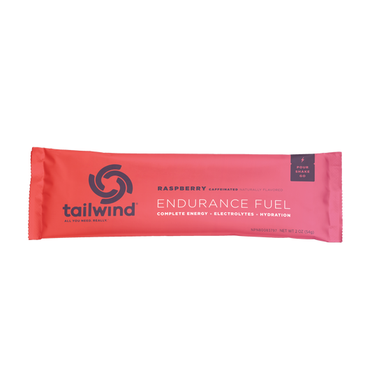 A sealed packet of Tailwind Endurance Fuel in raspberry flavor with the brand logo and product information visible on the front.